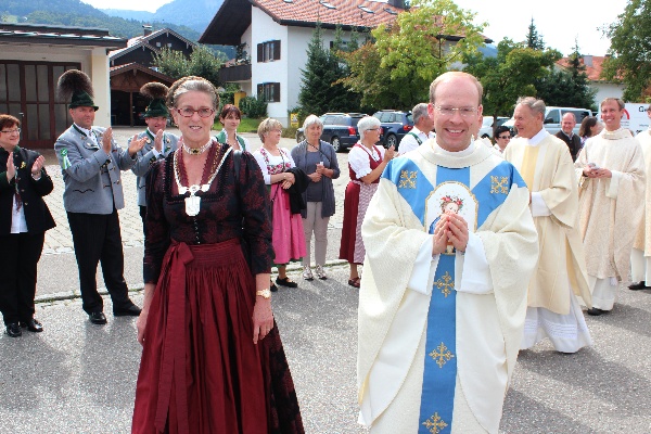 Der Primiziant wird von Bürgermeisterin begleitet und die Leute stehen Spalier