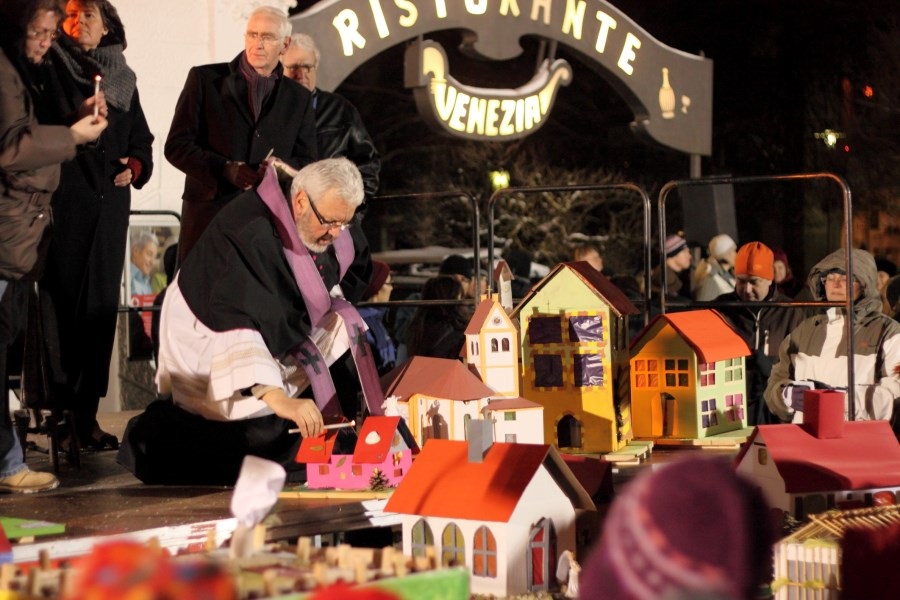 Pfarrer zündet Kerze an