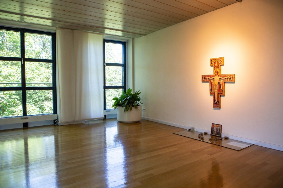 Meditationsraum mit Holzboden und Wandkreuz