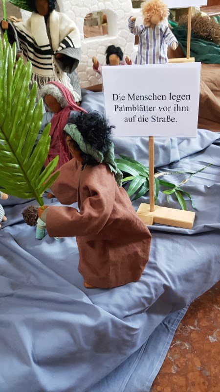 Die Menschen legen Palmblätter vor ihm auf die Straße.