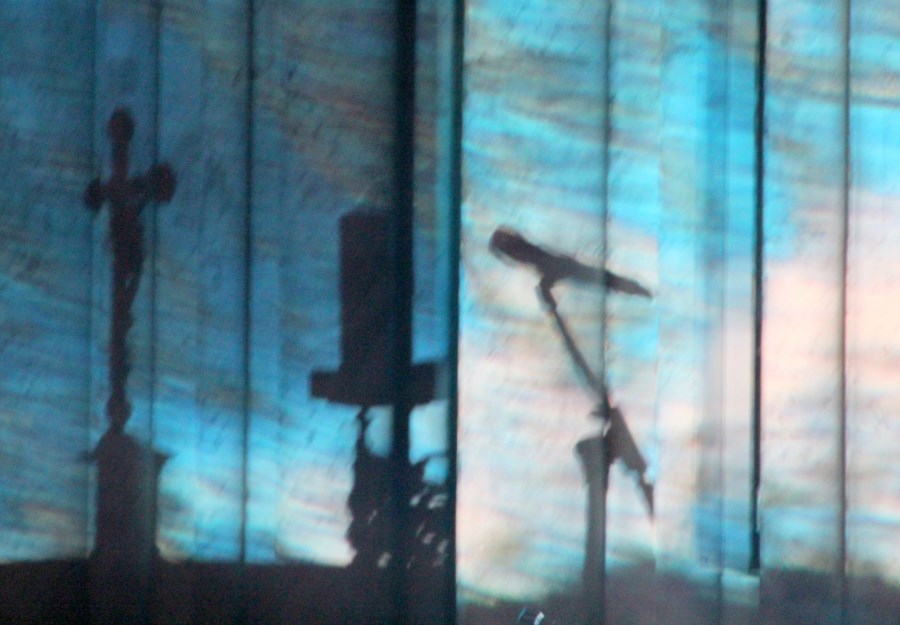 Schatten von Kreuz, Kerze und Mikro