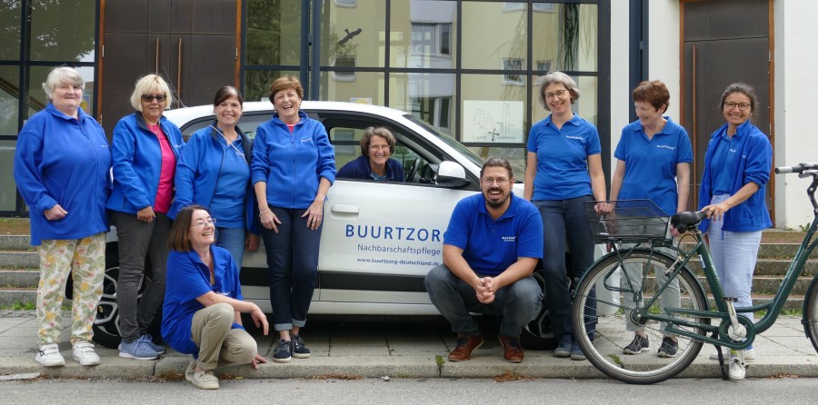 Mitarbeiter-Team mit Buurtzorg-Auto