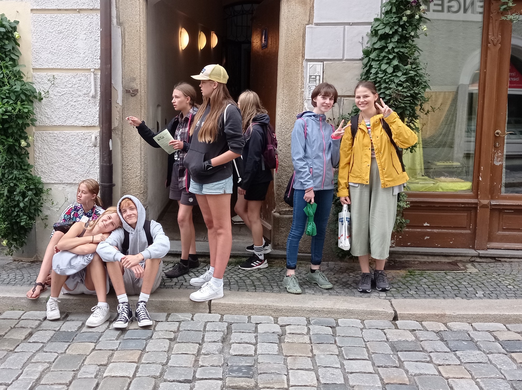 Eine kleine Ministrantengruppe von acht Minis stehen mit einer Karte in der Hand vor einem Geschäft und rätseln, wie die Schnitzeljagd nun weitergeht.