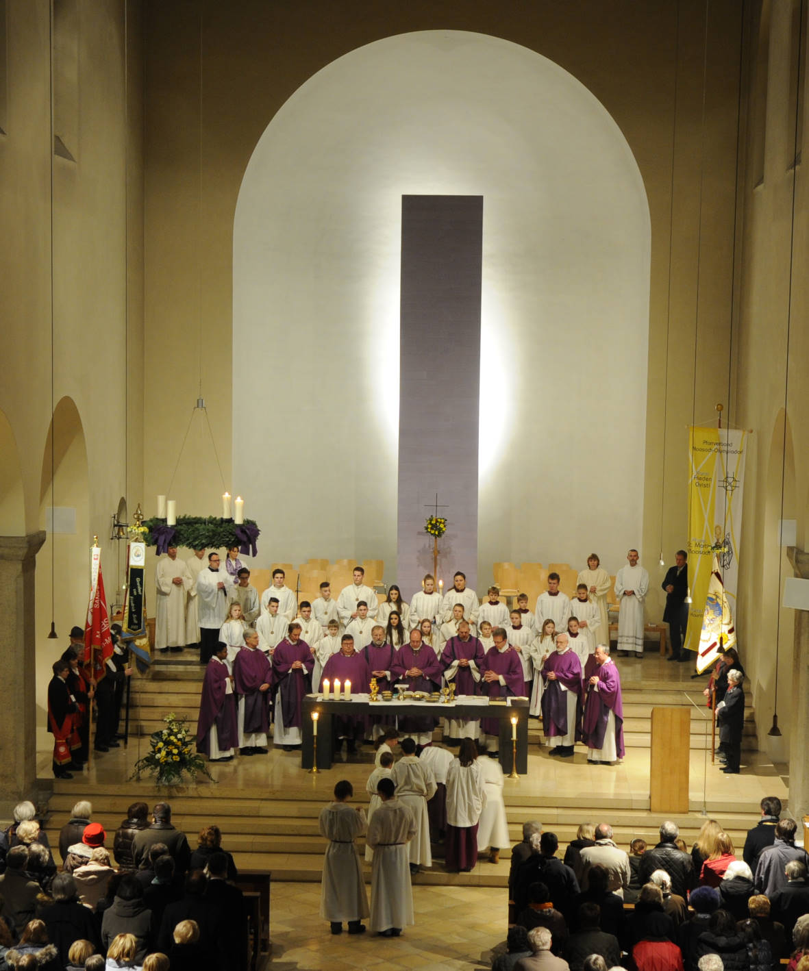 Blick in den Altarraum. Alle Pfarrer und Hauptamtlichen stehen am Altar. Im Altarraum sieht man Fahnenabordnungen