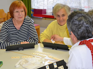 Drei Damen sitzen an einem Tisch und spielen Rubikon