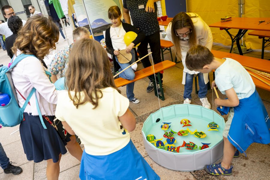 Kinder angeln Spielfische an einem Stand auf dem Bennofest in der Münchner Fußgängerzone