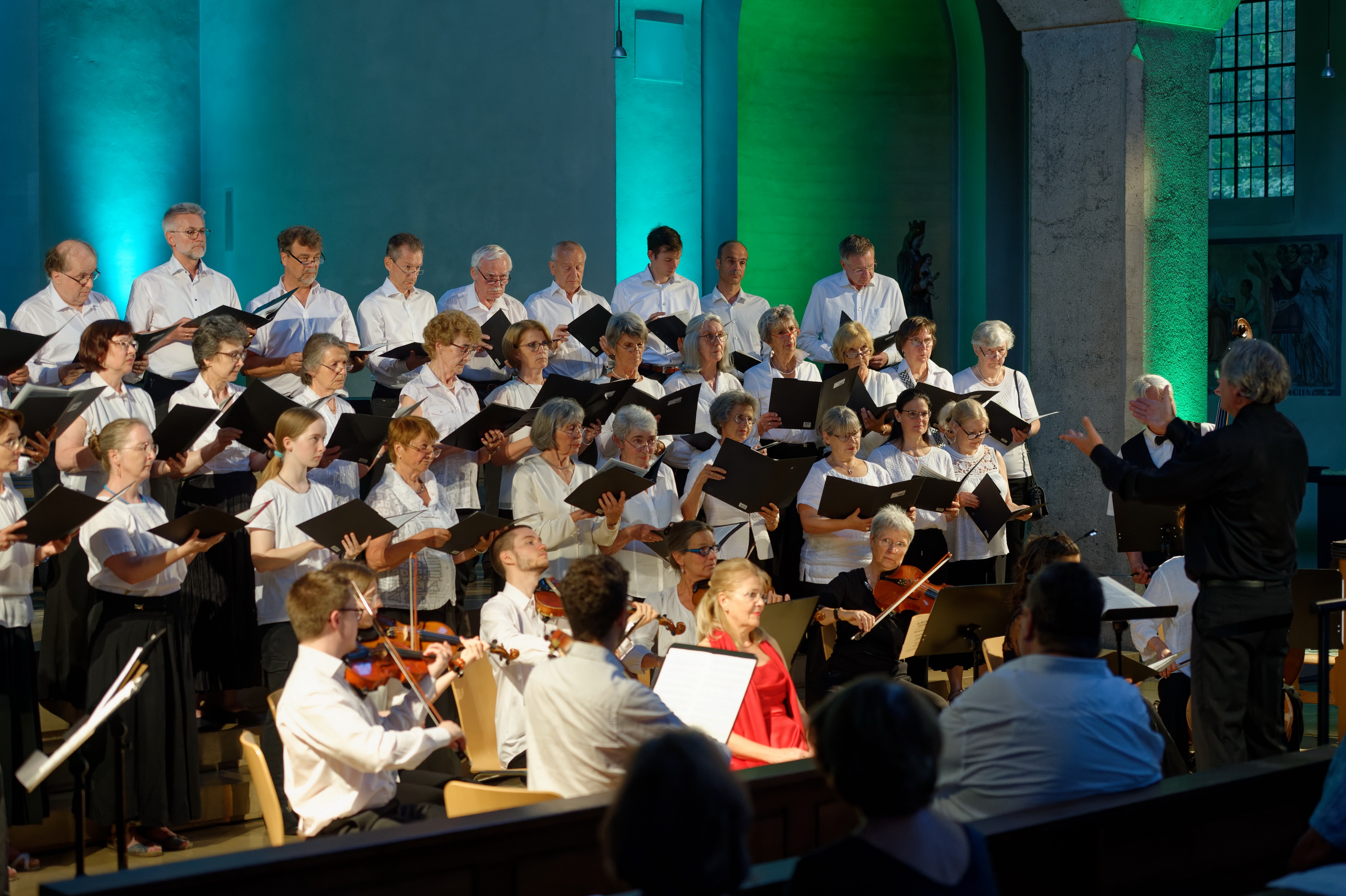 Das Bild zeigt einige Sängerinnen und Sänger während eines Konzerts in der Kirche.