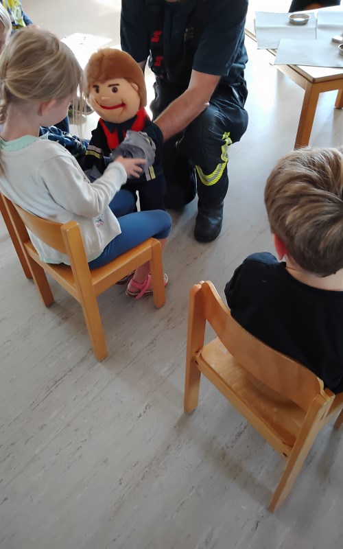 Der kleine Feuerwehrmann "Flixi" (eine Handpuppe) erklärt den Kinder das "gute" und das "schlechte" Feuer.