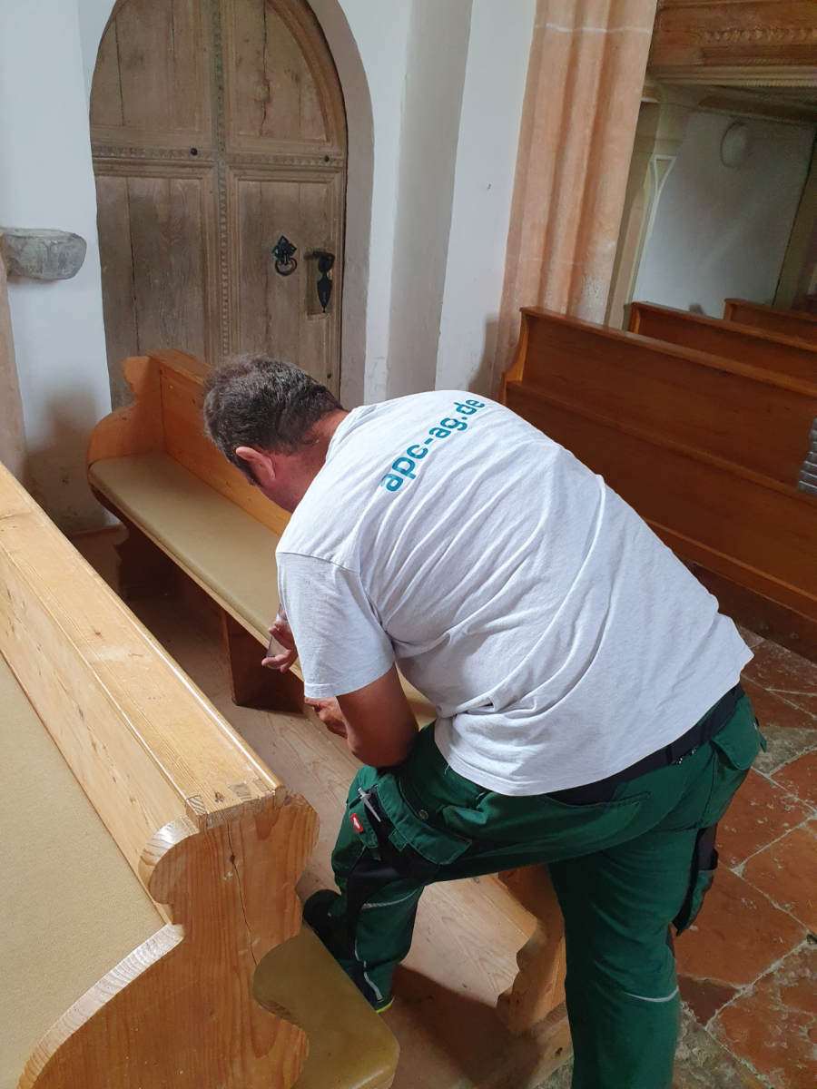 Mitarbeiter der Firma APC bringen in der Filialkirche Mehring die ersten Schlupfwespen ein.