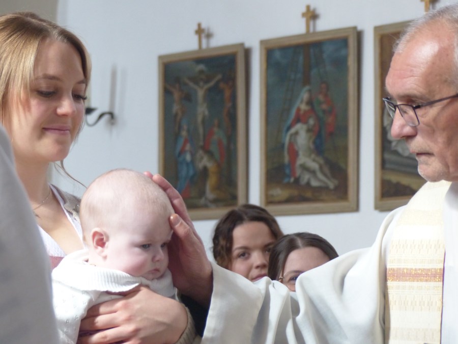 Täufling bekommt das Kreuzzeichen auf die Stirn