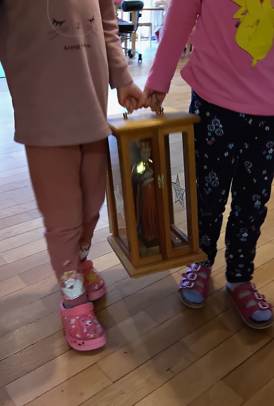 Die Marienfigur wird feierlich an eine Kinderhausfamilie übergeben.