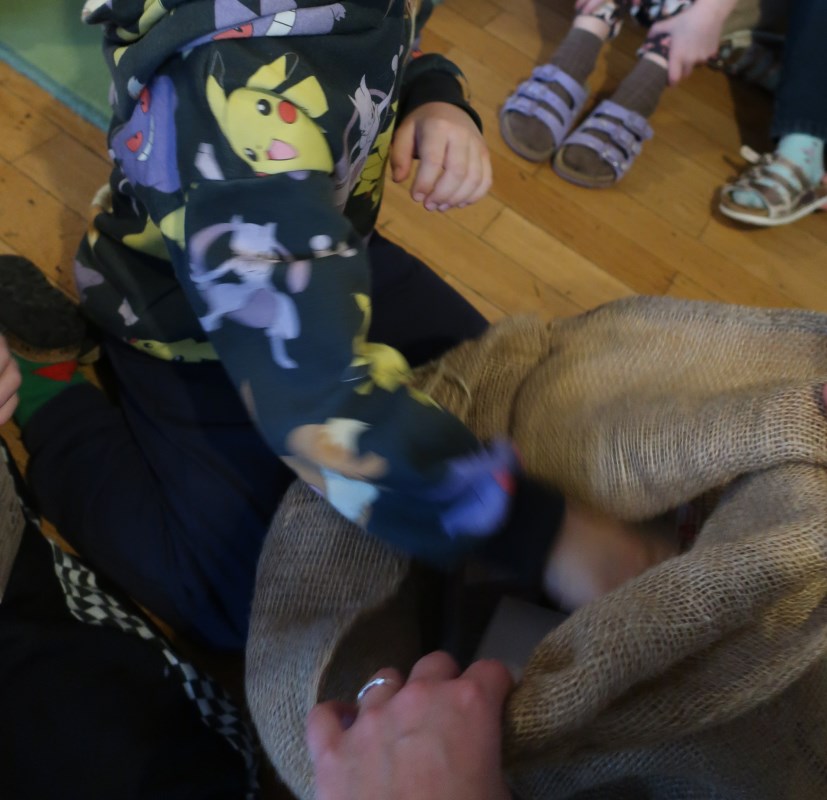 Die Kinder öffnen gemeinsam den Sack des Heiligen Nikolaus