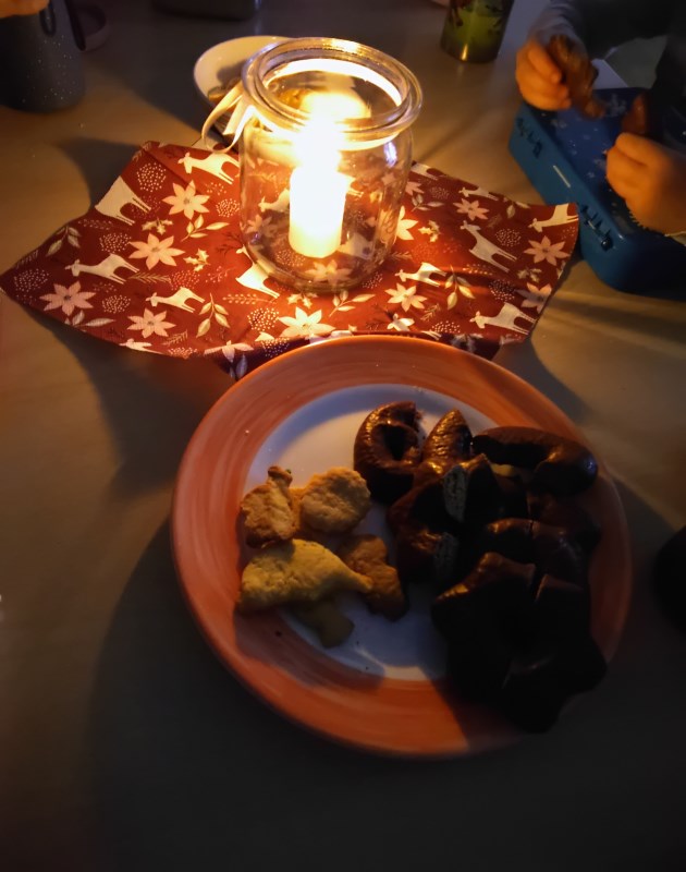 Die Kinder essen Plätzchen, Lebkuchen, Mandarinen und Äpfel.