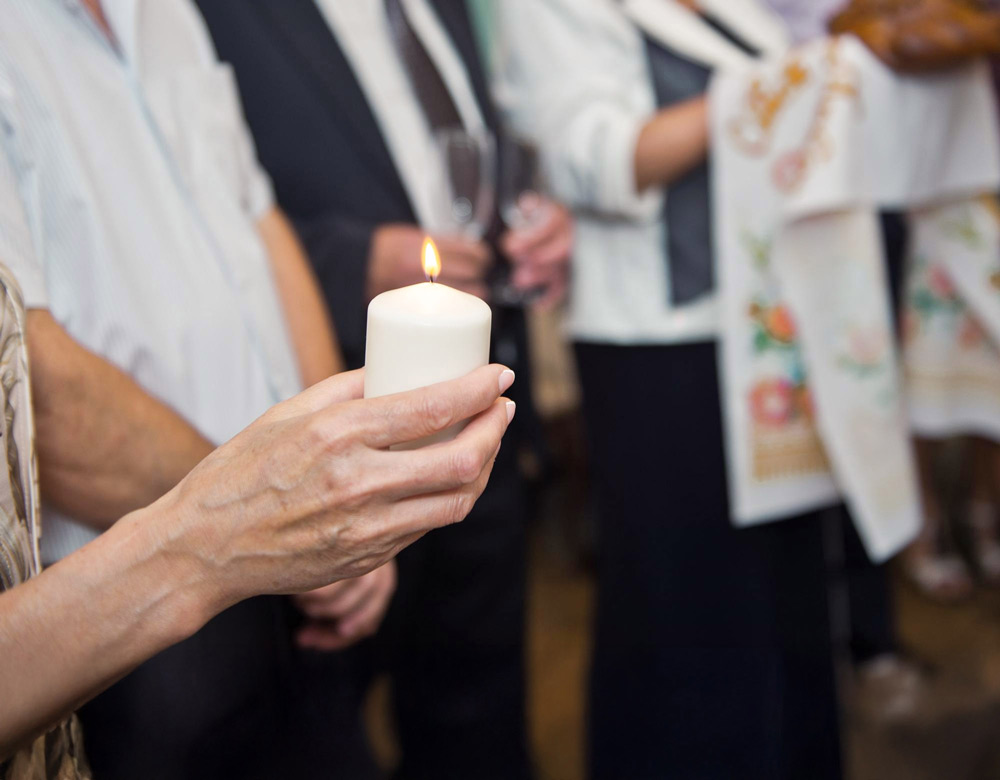 kerze haltende hände auf einer osterfeier
