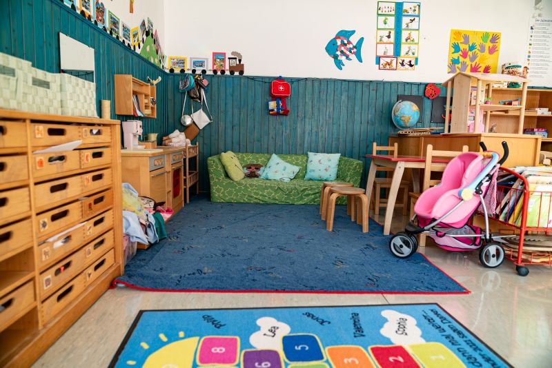 Spielecke mit Spielküche, Tisch, Buggy und anderen Spielsachen in der KiTa St. Lukas