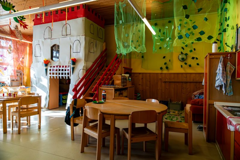 Gruppenraum mit Stühlen und Tischen und Spielturm in der Kita St. Markus