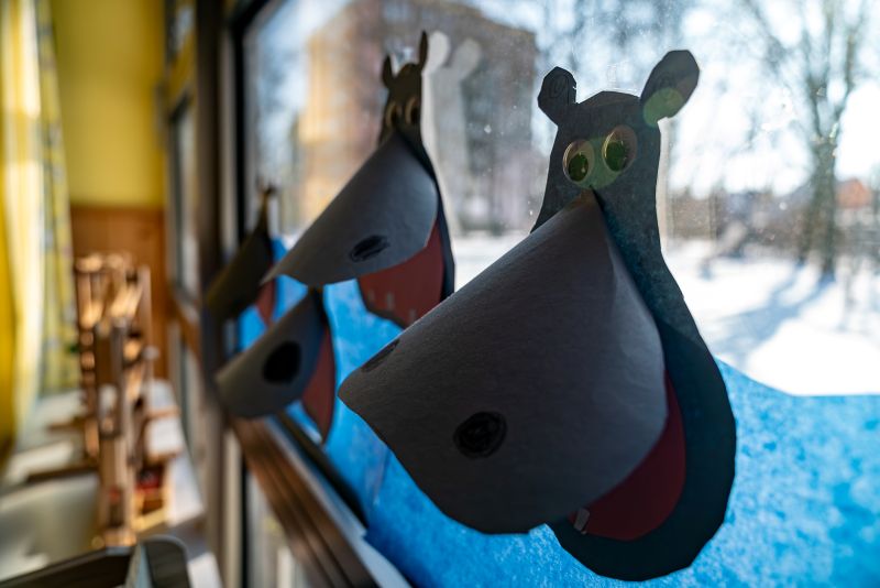 Gebastelte Nilpferdköpfe als Fensterdeko in der Kita St. Markus
