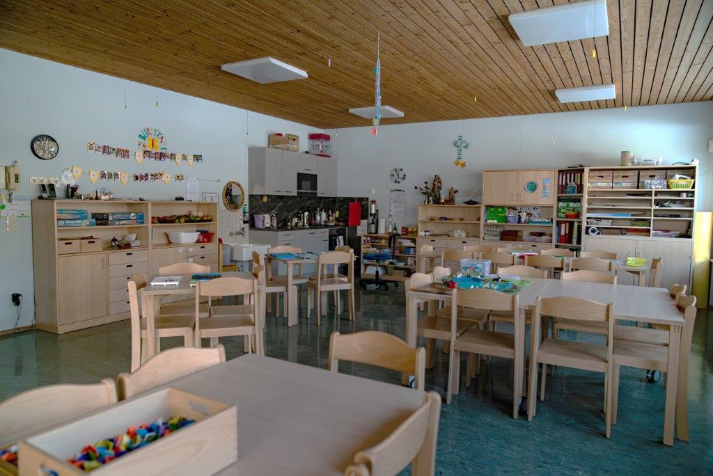 Gruppenraum des Horts mit Tischen und Stühlen im Kinderhaus Maria Schutz