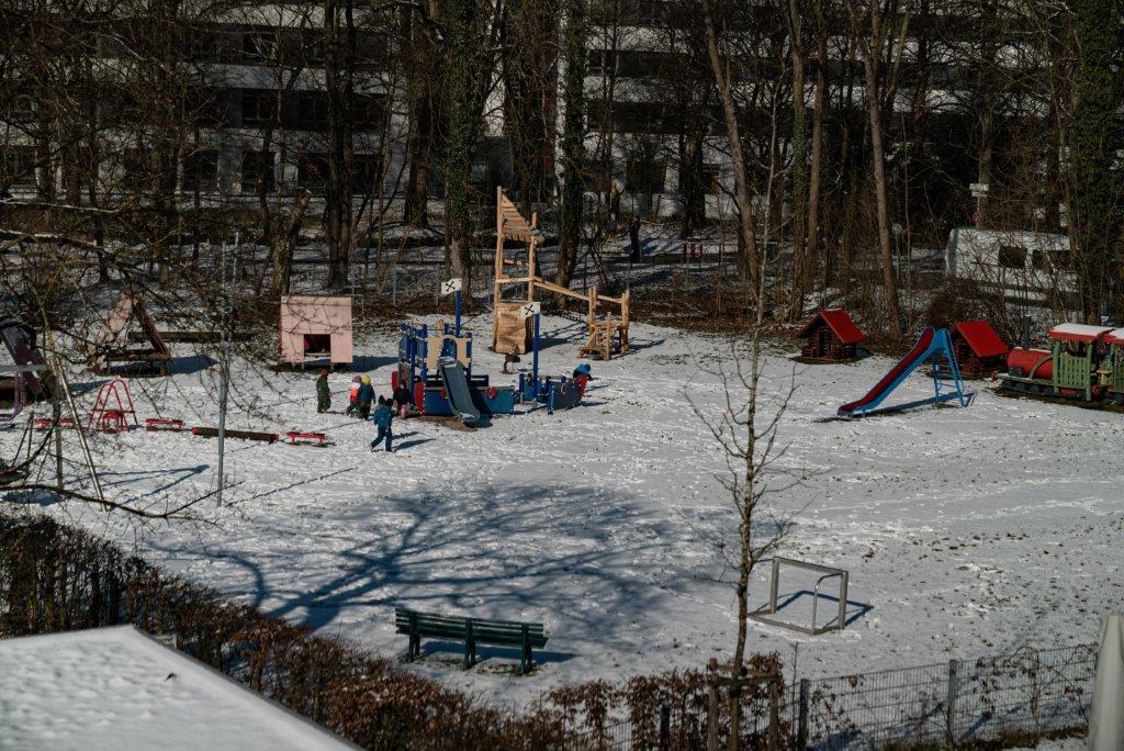 Verschneite Wiese mit Kletter-Piratenboot und anderen Klettergerüsten im Kinderhaus Maria Schutz