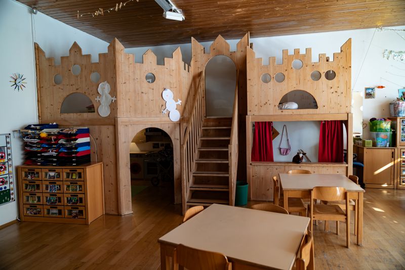Hölzernes Spielhaus als Burg mit Treppenaufgang und Höhle im Gruppenraum der Kita St. Hildegard.