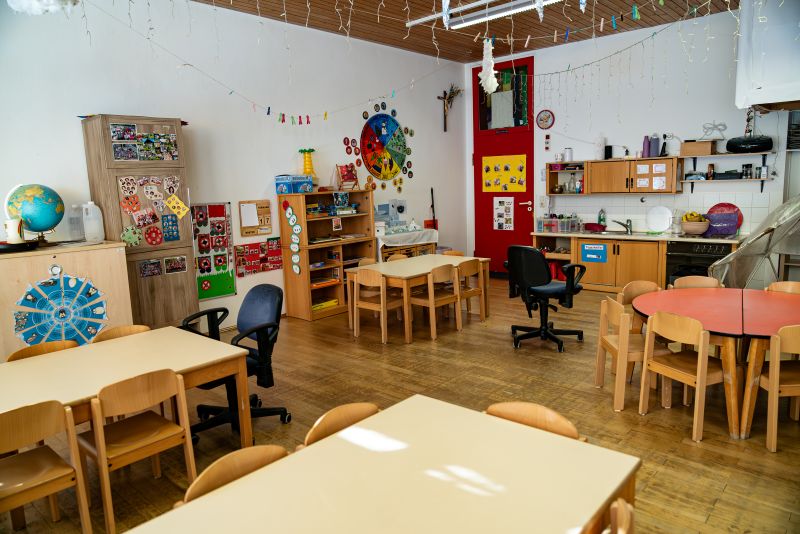 Gruppenraum mit Tischen und Stühlen in der Kita St. Hildegard.