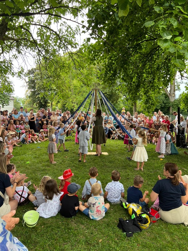 Die Kinderhauskinder singen und zeigen einen Bandltanz.