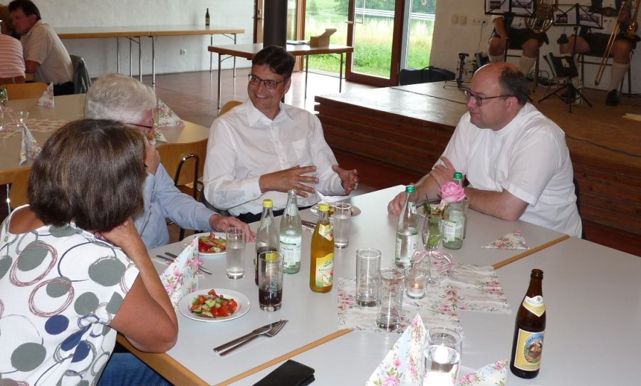 Landrat Max Heimerl unterhält sich am Tisch