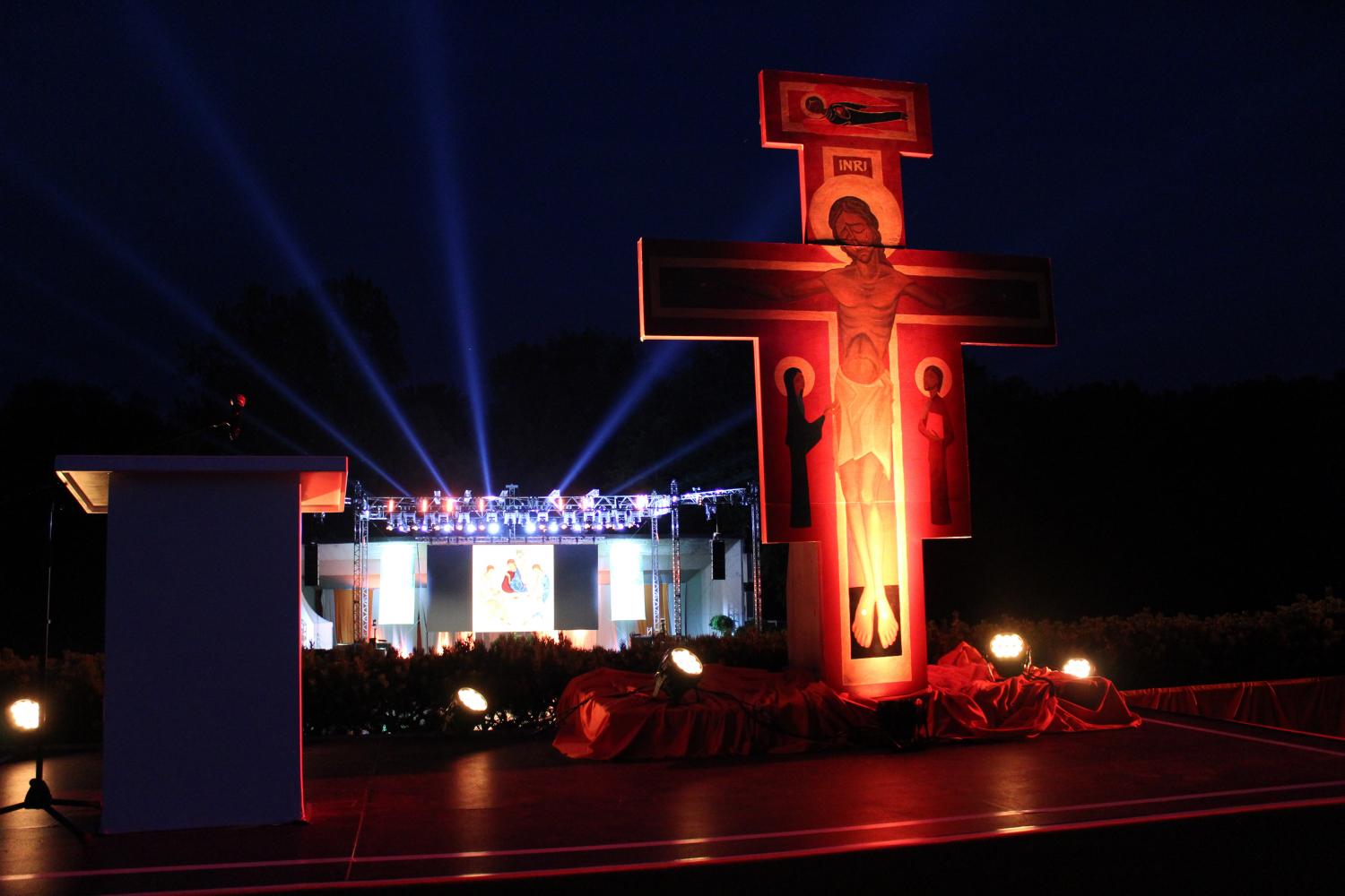 Taizekreuz (im Hintergrund eine erleuchtete Bühne)