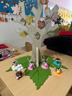 Baum mit gebastelten Blättern und Früchten und Kastanientieren darunter