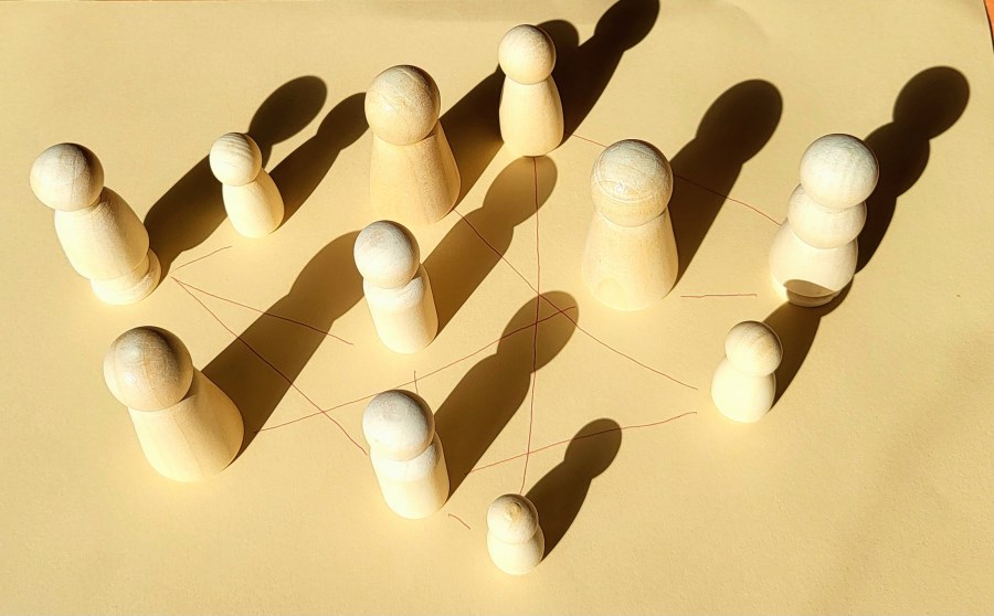Holzfiguren, die mit Linien verbunden sind