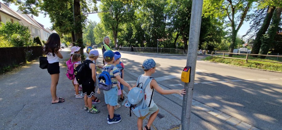 Kinder stehen an einer Ampel