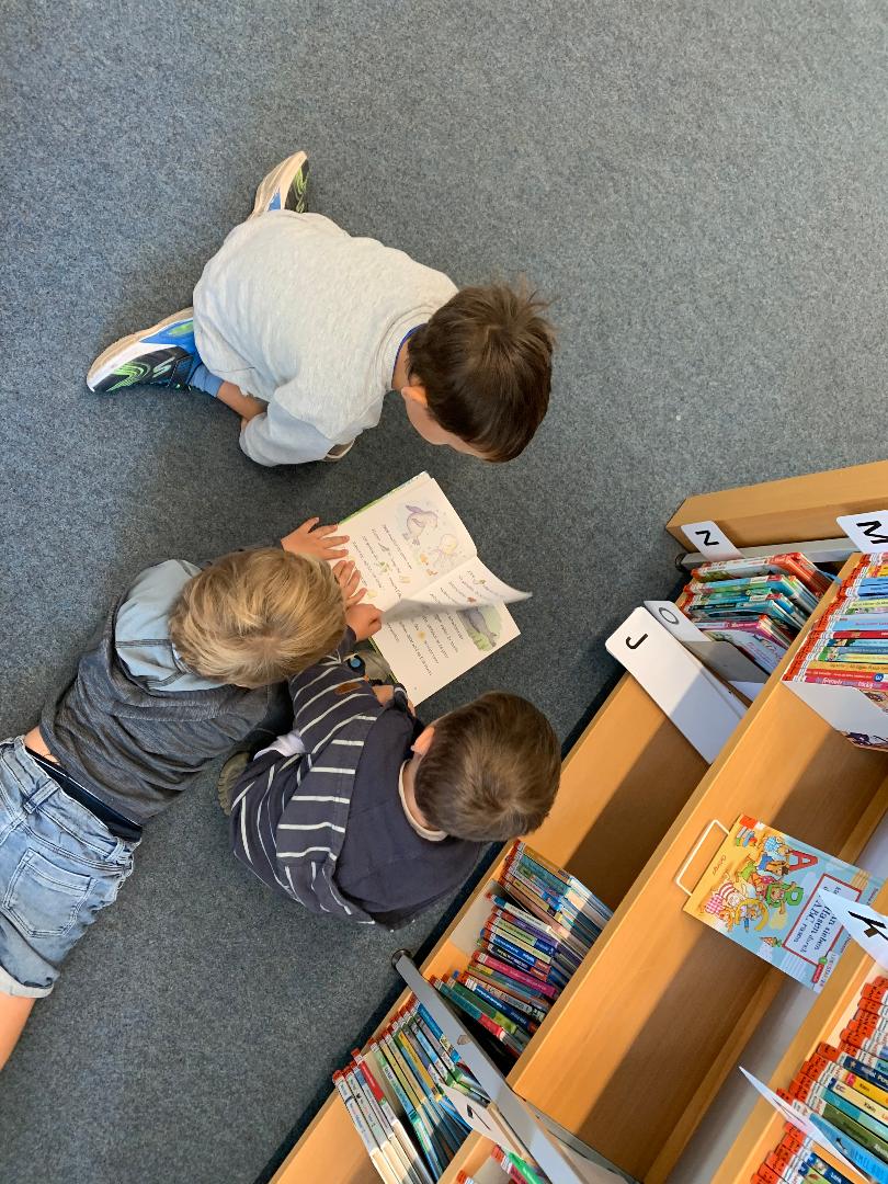 Kinder schauen Buch an