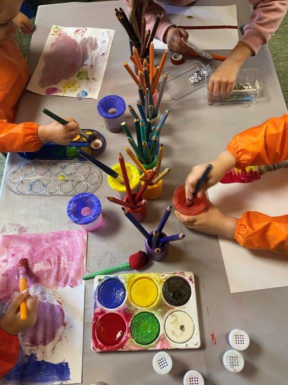 Wasserfarben, Buntstifte und Malpaier. Kinderhände malen.