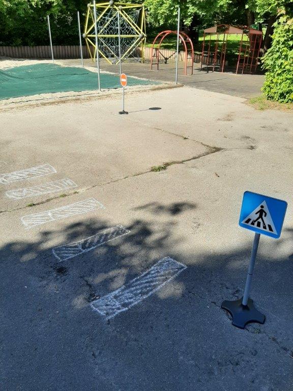 Zebrastreifen mit Straßenkreide und Verkehrsschild