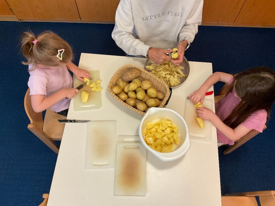 Kinder schneiden Kartoffeln