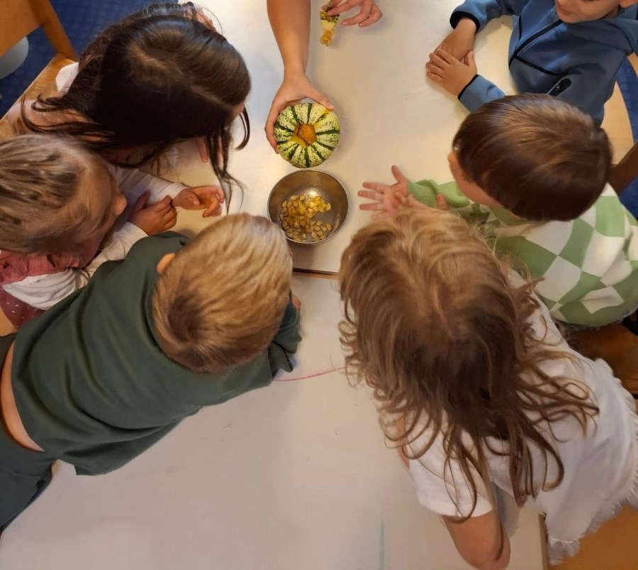 Kinder sind um Kürbis versammelt