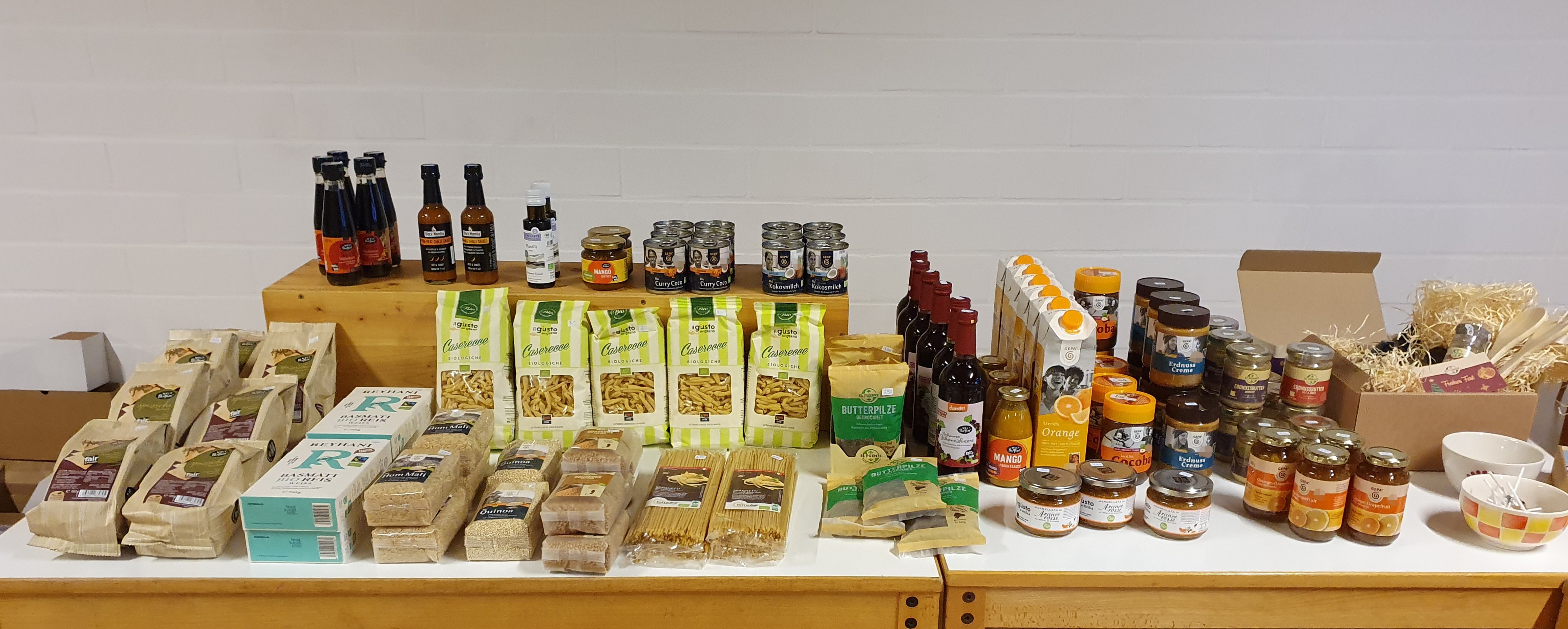 Waren des Eine-Welt-Tisches, v.a. Nudeln, Reis, Kokosmilch, Saft und Sirup, Marmelade